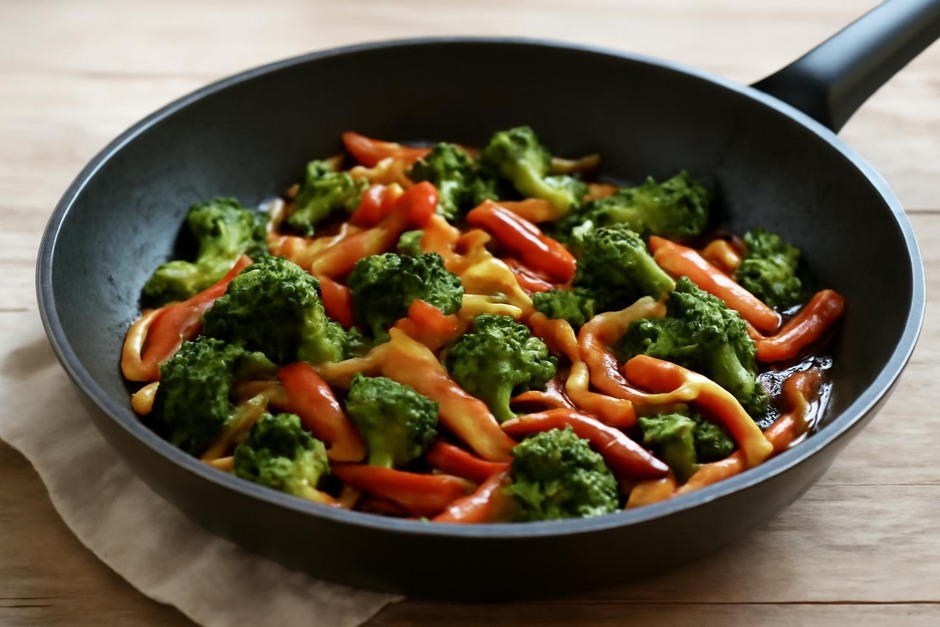 A skillet with colorful stir-fried vegetables and glossy sauce